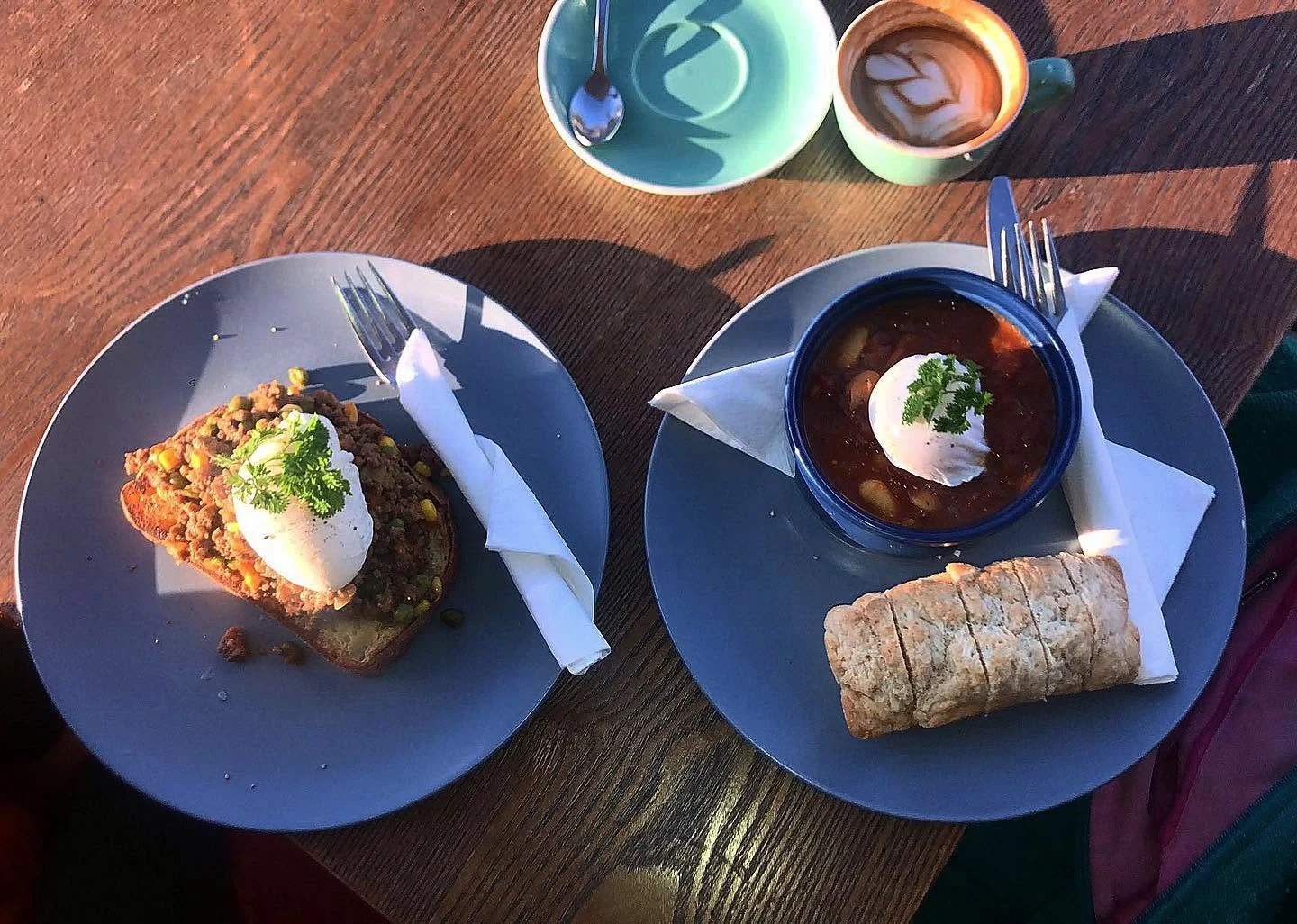 Two breakfasts and coffee on a sunlit wooden table at Ellen and Rod