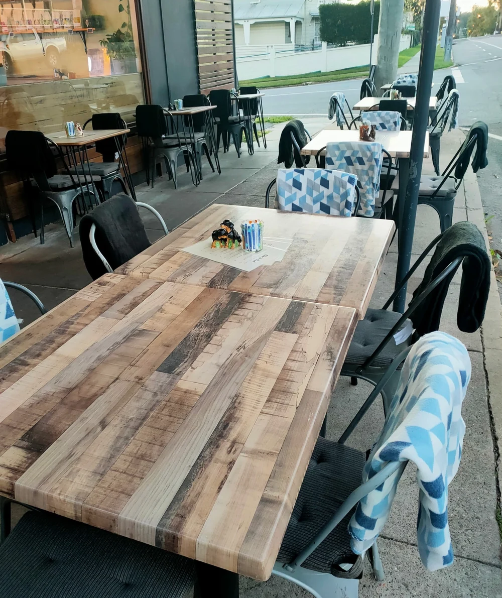 Outdoor wooden tables and chairs at Ellen and Rod’s street corner café